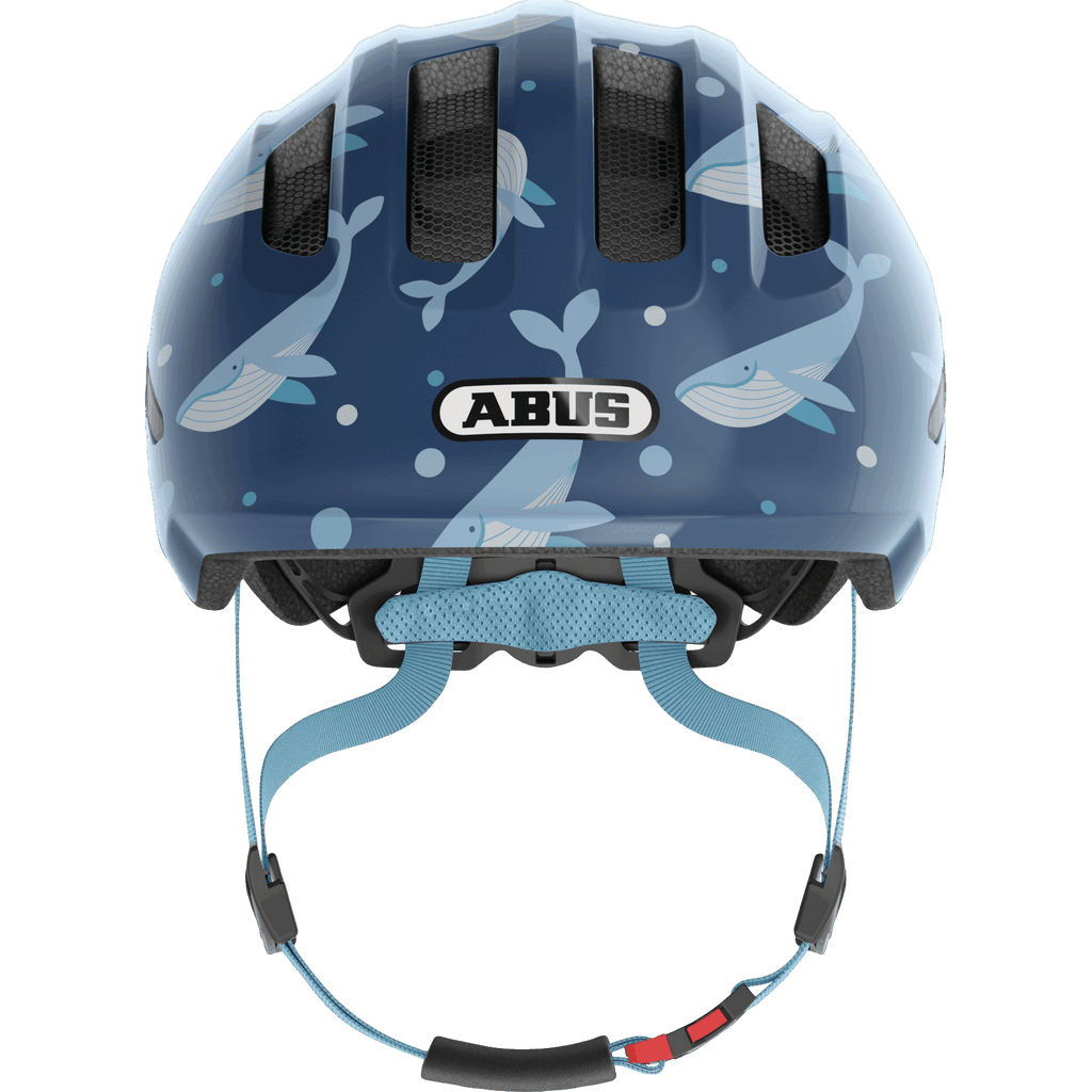 Der Abus - Smiley 3.0 von Abus ist ein blauer Kleinkinderhelm mit schwarzen Belüftungsöffnungen, weißem Wal- und Seifenblasendesign, hellblauem Kinnriemen, guter Belüftung und erweitertem Schutz nach vorne.