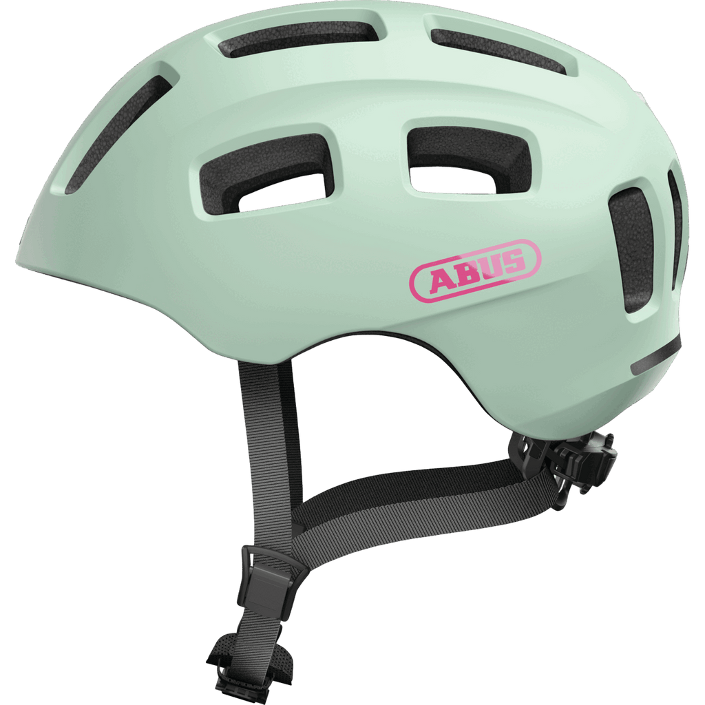 Der Abus Youn-I 2.0 ist ein hellgrüner Kinderhelm mit schwarzen Belüftungslöchern, verstellbaren schwarzen Riemen und erweitertem Schutz. Der Schriftzug "Abus" erscheint in Rosa auf der Seite.